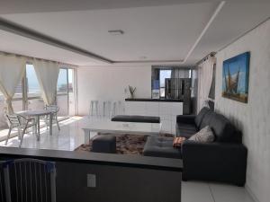 sala de estar con sofá y mesa en luxuosa cobertura praia do futuro 1001, en Fortaleza