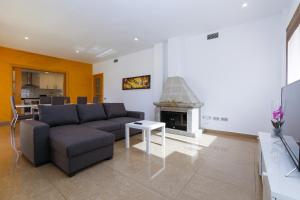 a living room with a couch and a fireplace at Nina Villa Planetcostadorada in Tarragona