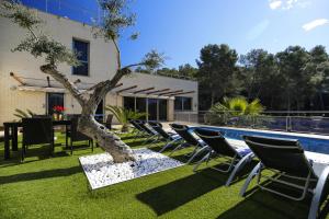 a yard with chairs and a tree next to a pool at Nina Villa Planetcostadorada in Tarragona