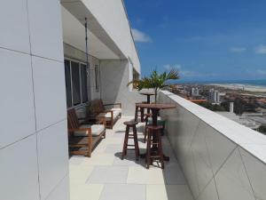 - Balcón con mesa y sillas en un edificio en luxuosa cobertura praia do futuro 1001, en Fortaleza