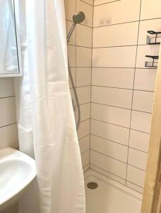 a bathroom with a shower with a white shower curtain at Unique Apartments in Döbling in Vienna