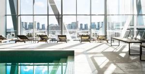 a room with chairs and a pool in a building at Fantastic Views at Luxury Prima Pearl Tower in Melbourne