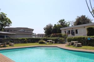 a swimming pool in front of a house at Hello Holiday at 4 Boboyi Mangrove Beach Estate in Port Shepstone