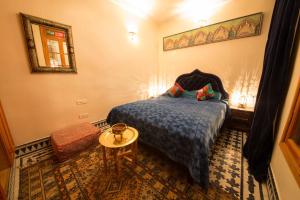 a bedroom with a bed and a table and a mirror at Riad Scalia Traditional Guesthouse Fes Morocco in Fès