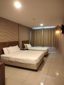 Hotel Jelai @ Raub, Pahang في راوب: غرفه فندقيه سريرين وتلفزيون