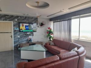 sala de estar con sofá y TV en luxuosa cobertura praia do futuro 1001, en Fortaleza