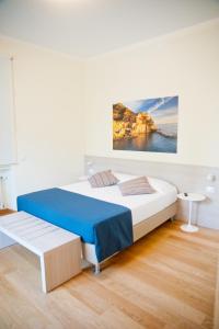 a bedroom with a bed and a painting on the wall at B&B Via delle 5 Terre in La Spezia