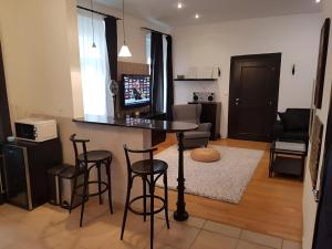 cocina y sala de estar con barra y taburetes en Cozy Apartment in the Middle of Bratislava, en Bratislava