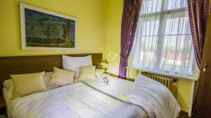 a bedroom with a bed with white sheets and a window at Hotel Veba in Broumov