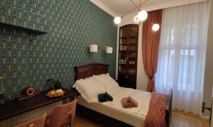 a bedroom with a bed and a table and a window at Kamienica w Solankach in Inowrocław