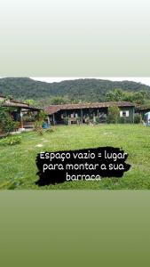 een bord voor een tuin met een gebouw bij Farah Camping Smartcamp hospedagem econômica in Boicucanga