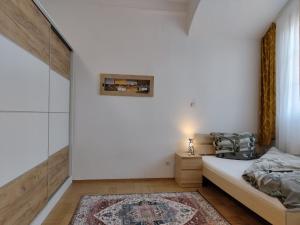 1 dormitorio con paredes blancas, 1 cama y 1 alfombra en Altstadtparee, en Steyr