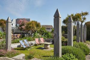 a group of chairs and a bench in a garden at Wentworth Hotel in Aldeburgh