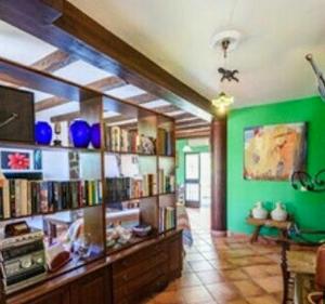 a library with green walls and shelves of books at 2 bedrooms house with private pool and terrace at El Bosque in El Bosque