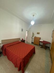 a room with a bed with a red bedspread on it at GELSOMINO in Levanto