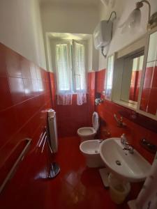 a red bathroom with two toilets and a sink at GELSOMINO in Levanto