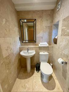 a bathroom with a toilet and a sink at Mimosa Cottage in Farnham