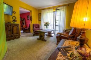 una sala de estar con paredes amarillas y una mesa. en Jaś Wędrowniczek, en Rymanów