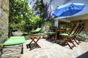 a patio with chairs and a table with an umbrella at Apartments Ivan in Makarska