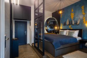 a bedroom with a bed with a blue wall at Studio Apartman Stari Toranj IV in Vukovar