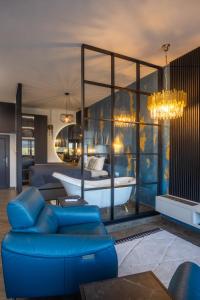 uma sala de estar com um sofá azul e uma banheira em Studio Apartman Stari Toranj IV em Vukovar