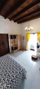 ein Schlafzimmer mit einem großen Bett und einem Kronleuchter in der Unterkunft Suite casa rural Los Patios, CONIL in Tías