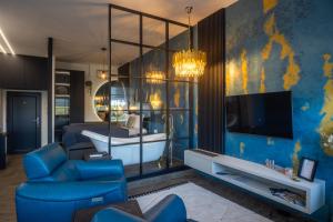 a room with a bed and a couch and a tv at Stari Toranj IV studio apartman in Vukovar