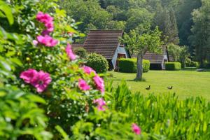 a group of houses in a yard with pink flowers at Domaine Long Pre in Stavelot