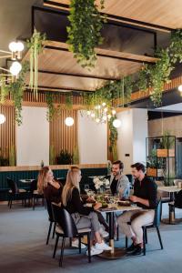 un groupe de personnes assises à une table dans un restaurant dans l'établissement Artis Loft Hotel, à Radziejowice