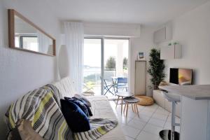sala de estar blanca con sofá y cocina en Casa del mare - magnifique appartement vue mer, en La Seyne-sur-Mer