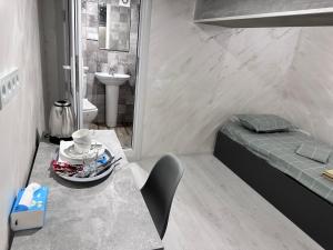 a small room with a bed and a sink and a table at Mandarin Hotel in Yerevan