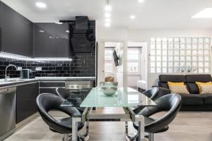 a kitchen with a glass table and leather chairs at Plaza España Apartment in Madrid