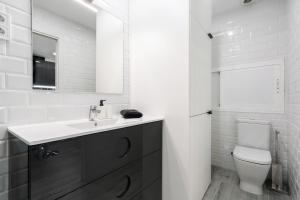 a white bathroom with a sink and a toilet at Plaza España Apartment in Madrid