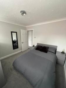 een slaapkamer met een groot bed en een spiegel bij Eaton Ford Green Ground Floor Apartment in Saint Neots