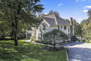 ein weißes Haus mit einem Baum und einer Auffahrt in der Unterkunft Merlins Escape in Newtown