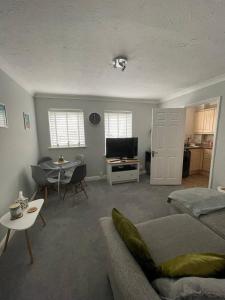 a living room with a couch and a table at Eaton Ford Green Ground Floor Apartment in Saint Neots