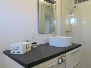 eine Badezimmertheke mit einem Waschbecken und einem Spiegel in der Unterkunft Appartement Trégastel, 2 pièces, 4 personnes - FR-1-368-77 in Trégastel