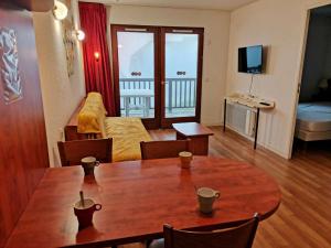 a living room with a dining room table and a living room with at Charmant T2 à La Mongie - Terrasse, Piscine Couverte, Salle de Fitness, Proche Pistes - FR-1-404-270 in La Mongie