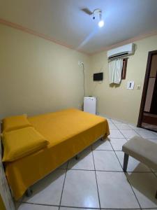 a bedroom with a yellow bed in a room at Casarão Hotel Pousada in São Luís
