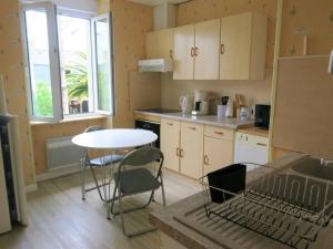 une petite cuisine avec une table et des chaises. dans l'établissement Appartement central à Trébeurden, 500m plage, proche commerces, 2 chambres, 3 salles d'eau - FR-1-368-308, à Trébeurden