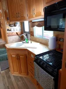 a kitchen with a stove and a sink in an rv at 40' RV Move in Ready in Jordan