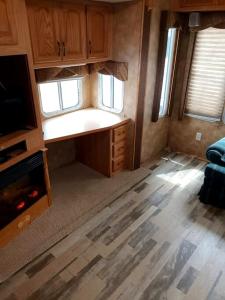 an empty room with a kitchen and a living room at 40' RV Move in Ready in Jordan