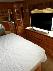 a bedroom with a bed and a flat screen tv at 40' RV Move in Ready in Jordan