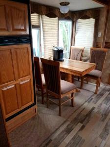 a dining room with a wooden table and chairs at 40' RV Move in Ready in Jordan