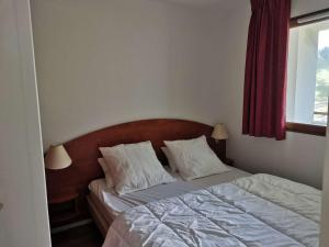 - une chambre avec un lit doté de draps blancs et une fenêtre dans l'établissement Appartement La Mongie, 2 pièces, 4 personnes - FR-1-404-265, à Bagnères-de-Bigorre