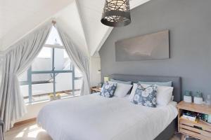 een slaapkamer met een bed en een groot raam bij Big Bay Hilltop Villa in Kaapstad