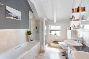 een badkamer met een bad, een toilet en een wastafel bij Big Bay Hilltop Villa in Kaapstad +13 foto's