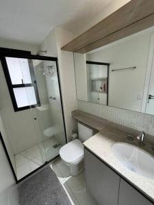 La salle de bains est pourvue de toilettes, d'un lavabo et d'une douche. dans l'établissement Apto Novo Maracanã/Tijuca, à Rio de Janeiro