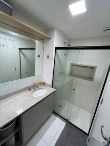 a bathroom with a sink and a glass shower at Apto Novo Maracanã/Tijuca in Rio de Janeiro