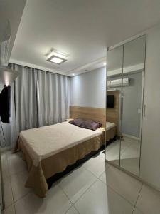 1 dormitorio con 1 cama y pared de cristal en Apto Novo Maracanã/Tijuca en Río de Janeiro